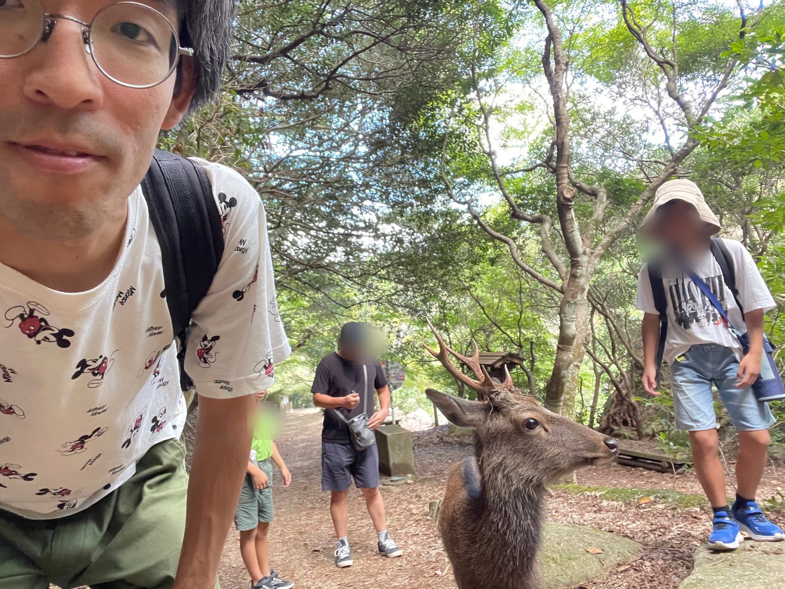 Ao taking a selfie with a deer on a forest path on Miyajima